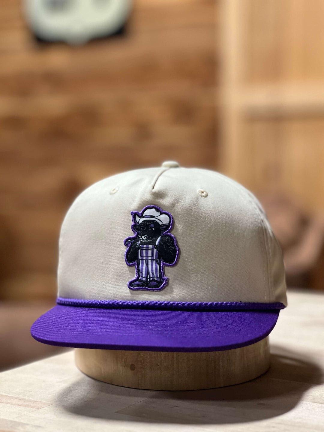 Outpost cap with Bull patch on the front panel of bone color top contrasted with purple front bill.