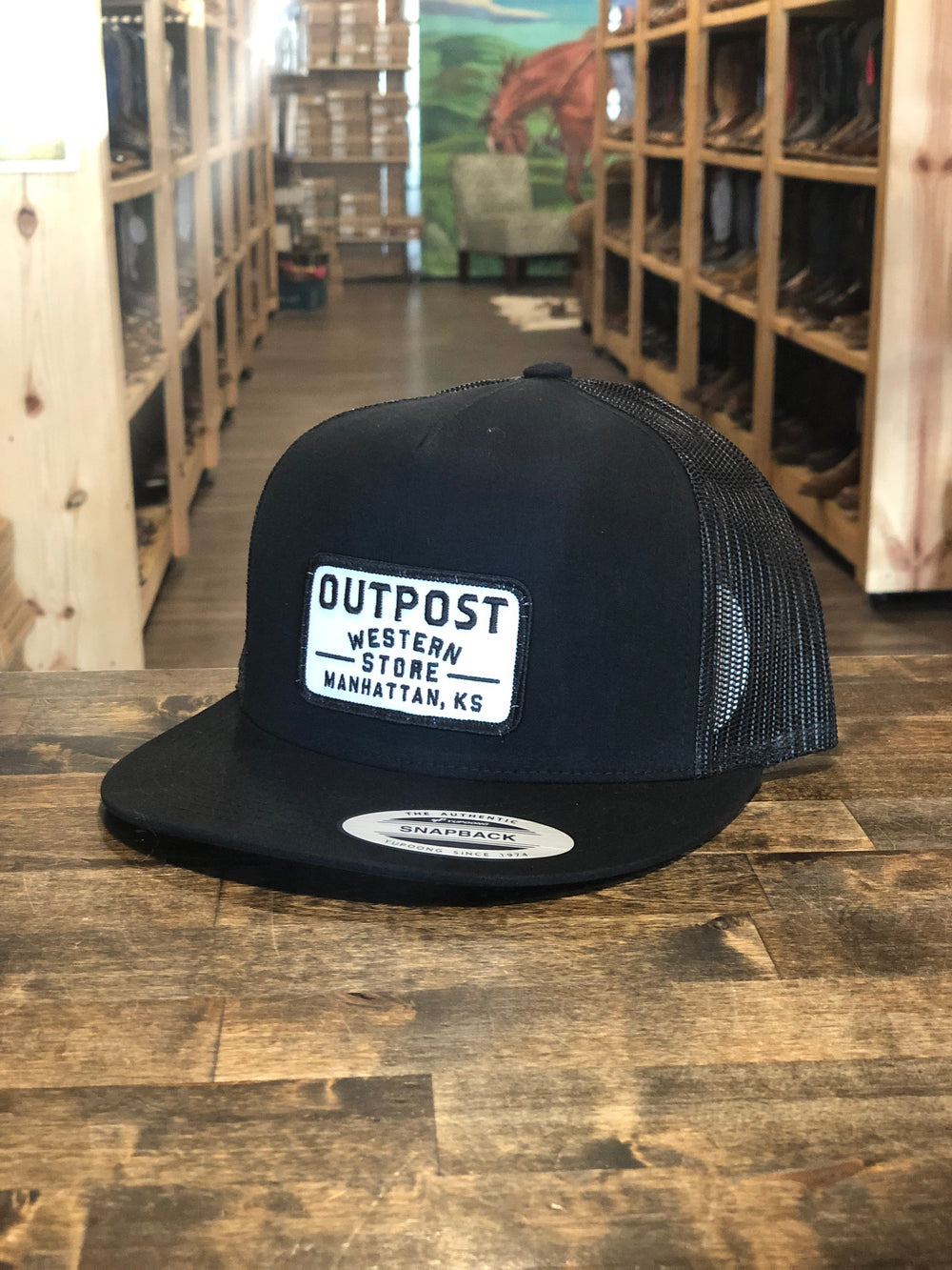 Black fabric with black mesh back, Outpost logo patch, Yupoong Trucker Cap